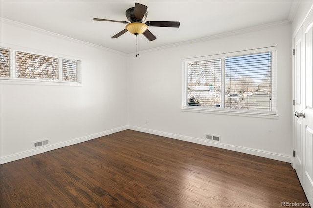 unfurnished room featuring ornamental molding, a wealth of natural light, dark wood-style flooring, and visible vents