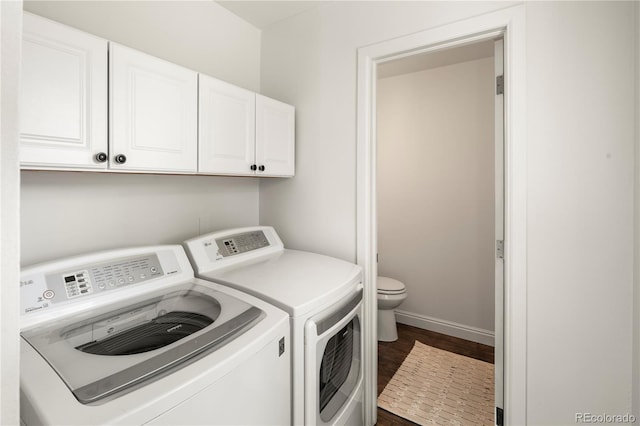 clothes washing area with dark wood-type flooring, laundry area, washer and clothes dryer, and baseboards