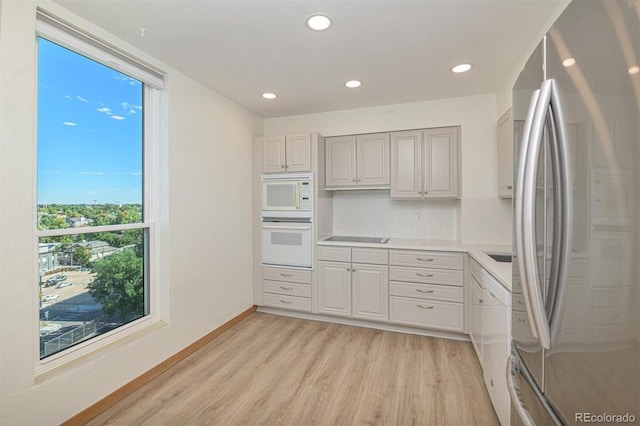 460 S Marion Pkwy Unit 1103, Denver, CO 80209 - kitchen featuring white appliances, light wood-type flooring, tasteful backsplash, recessed lighting, and light countertops