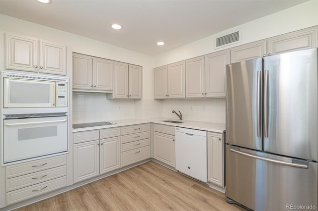 460 S Marion Pkwy Unit 1103, Denver, CO 80209 - kitchen featuring white appliances, light countertops, light wood finished floors, backsplash, and recessed lighting