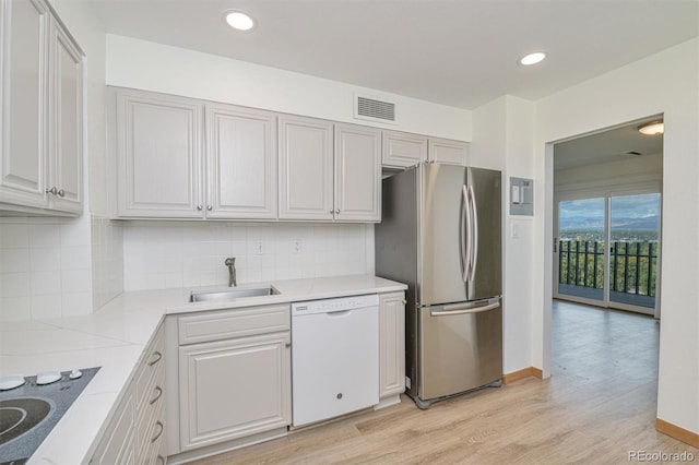 460 S Marion Pkwy Unit 1103, Denver, CO 80209 - kitchen featuring dishwasher, freestanding refrigerator, black electric stovetop, light wood-style flooring, and decorative backsplash