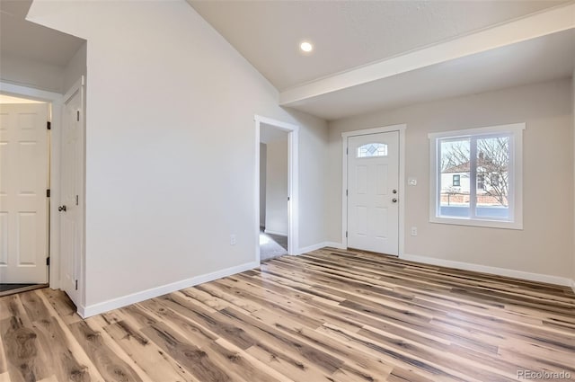 foyer entrance featuring lofted ceiling and light hardwood / wood-style floors