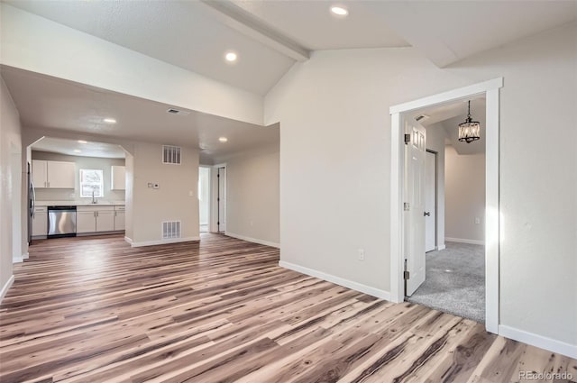 unfurnished living room featuring sink, vaulted ceiling with beams, a chandelier, and light wood-type flooring