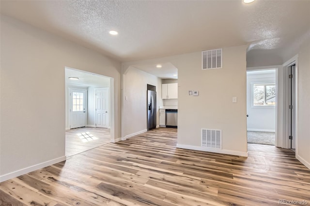 interior space featuring light hardwood / wood-style floors and a textured ceiling