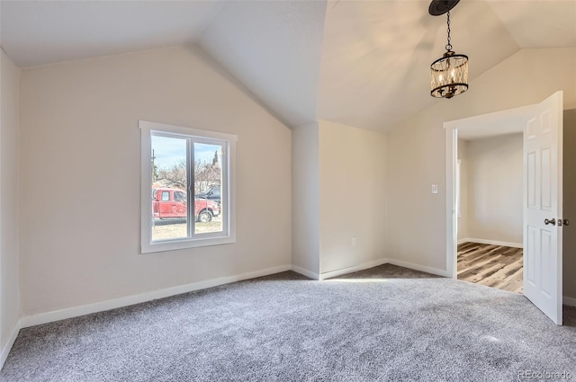 empty room with a notable chandelier, lofted ceiling, and carpet