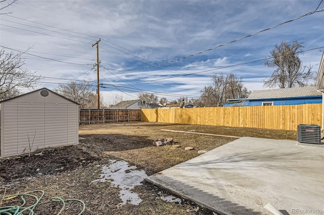 view of yard featuring a storage shed, central AC unit, and a patio area