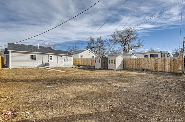 rear view of house with a lawn and a storage unit