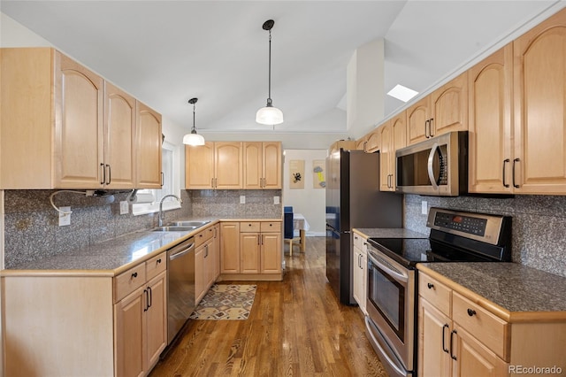 11035 E Berry Ave, Englewood, CO 80111 - kitchen with appliances with stainless steel finishes, light brown cabinetry, vaulted ceiling, dark wood-style flooring, and backsplash