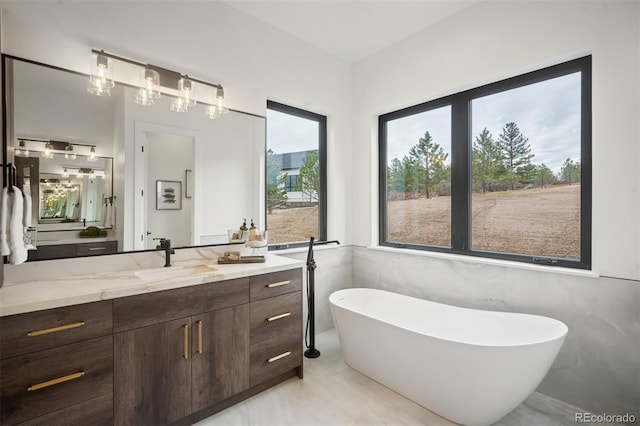 bathroom with vanity, a bathtub, and tile walls