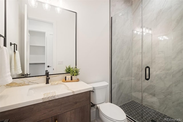 bathroom with vanity, toilet, and a shower with shower door