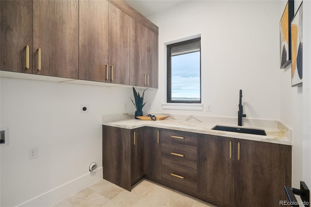 washroom with cabinets, electric dryer hookup, sink, and light tile patterned floors