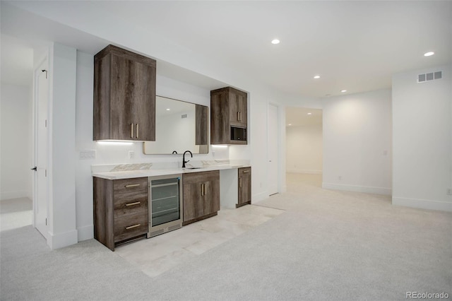 kitchen with wine cooler, sink, and light colored carpet