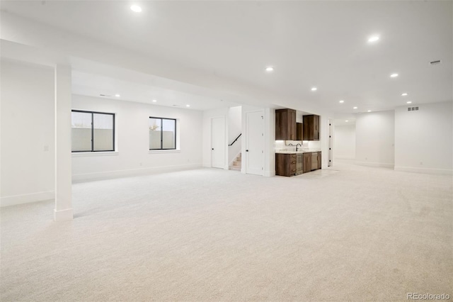 unfurnished living room featuring sink and light colored carpet