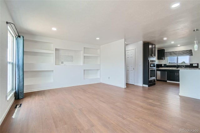 unfurnished living room featuring baseboards, recessed lighting, visible vents, and light wood-style floors