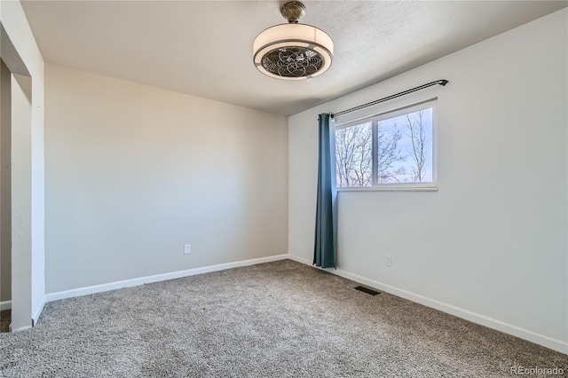 unfurnished room featuring carpet floors, baseboards, and visible vents