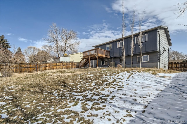 snow covered property with stairway, central AC, fence, and a deck