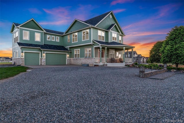 881 Kirby Ct, Watkins, CO 80137 - view of front of house with covered porch, stone siding, an attached garage, and driveway