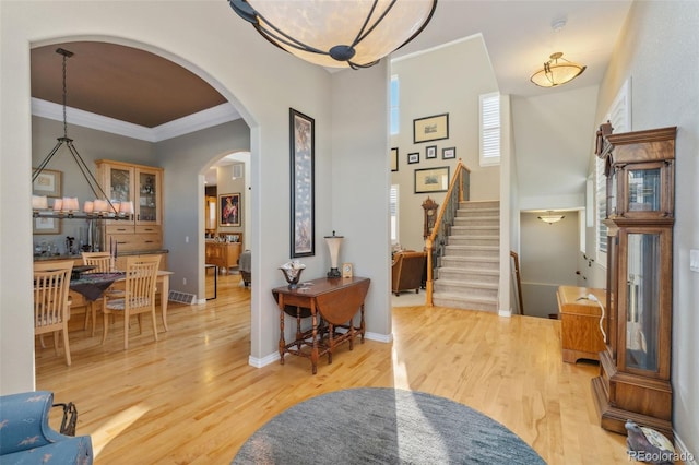 881 Kirby Ct, Watkins, CO 80137 - foyer entrance featuring arched walkways, light wood finished floors, stairway, and ornamental molding