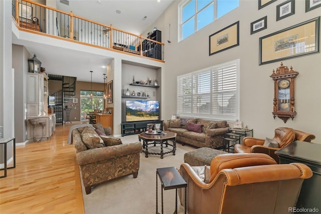 881 Kirby Ct, Watkins, CO 80137 - living area featuring plenty of natural light, a high ceiling, and light wood-style flooring