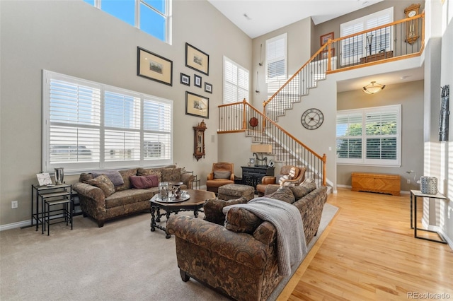881 Kirby Ct, Watkins, CO 80137 - living room featuring a towering ceiling, stairs, and wood finished floors