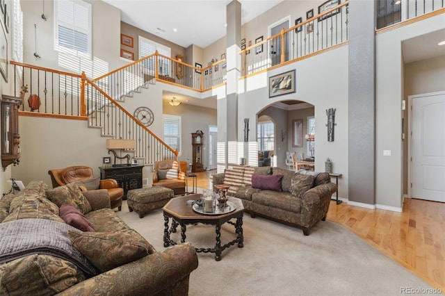 881 Kirby Ct, Watkins, CO 80137 - living room with arched walkways, wood finished floors, a high ceiling, and stairs