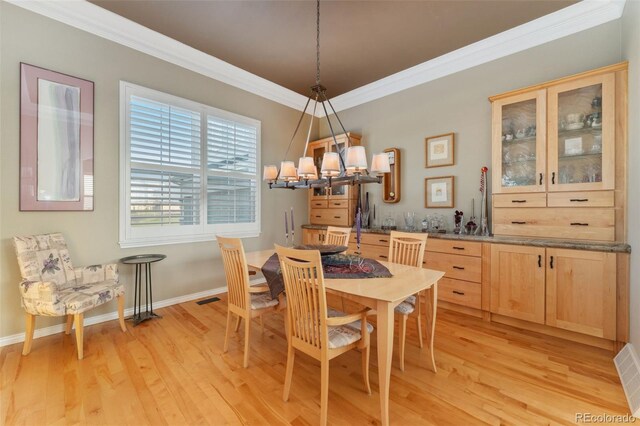 881 Kirby Ct, Watkins, CO 80137 - dining room featuring ornamental molding, a chandelier, and light wood-style flooring