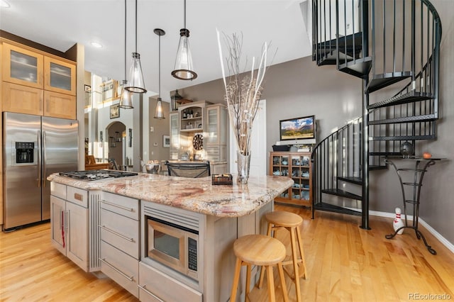 881 Kirby Ct, Watkins, CO 80137 - kitchen featuring stainless steel appliances, light wood-style floors, an island with sink, glass insert cabinets, and recessed lighting