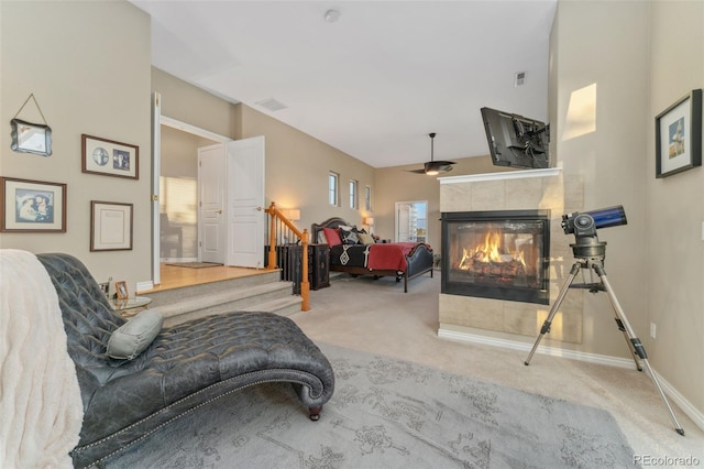 881 Kirby Ct, Watkins, CO 80137 - carpeted living area with a tile fireplace, stairs, and a ceiling fan