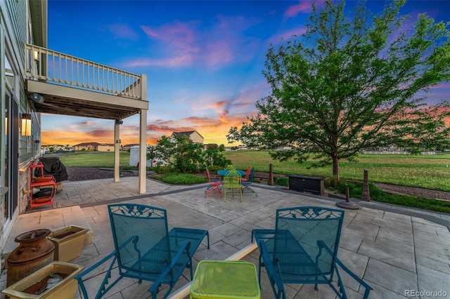 881 Kirby Ct, Watkins, CO 80137 - patio terrace at dusk with outdoor dining space, a patio area, a balcony, and a lawn