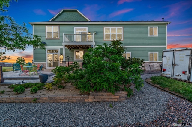 881 Kirby Ct, Watkins, CO 80137 - back of house featuring a balcony, a patio, and stone siding