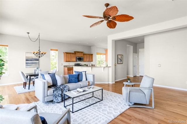 4519 Silver Mountain Loop, Broomfield, CO 80023 - living area featuring light wood-style flooring, ceiling fan, baseboards, and a chandelier