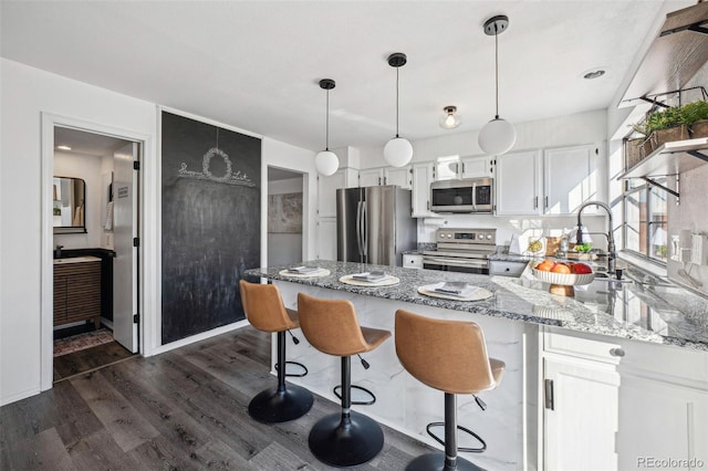 kitchen with appliances with stainless steel finishes, dark hardwood / wood-style floors, sink, white cabinets, and light stone counters