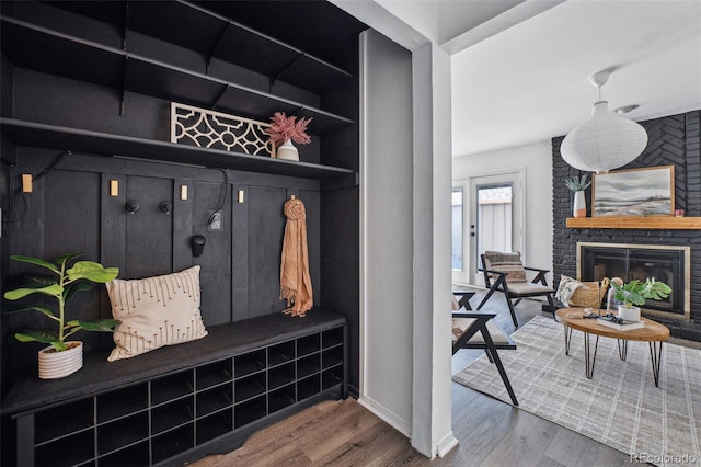 mudroom with hardwood / wood-style flooring and a brick fireplace