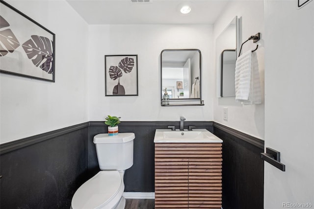 bathroom featuring hardwood / wood-style flooring, vanity, and toilet