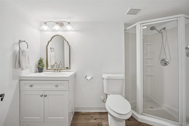 bathroom with vanity, wood-type flooring, toilet, and walk in shower