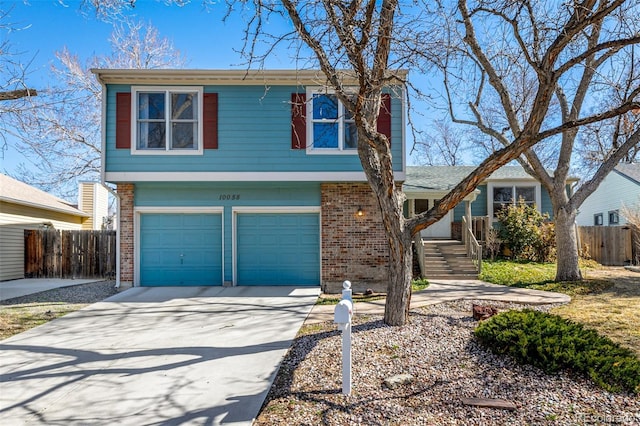 view of front of property featuring an attached garage, fence, brick siding, and driveway