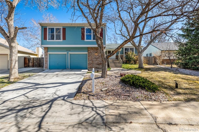 view of front of property with a garage, brick siding, driveway, and fence