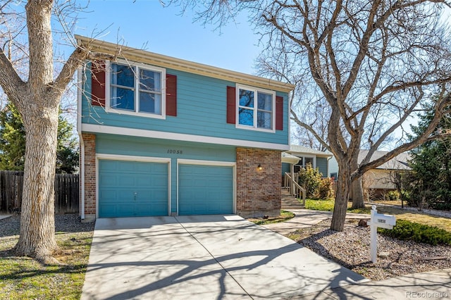 view of front facade with an attached garage, fence, brick siding, and driveway