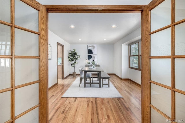 unfurnished dining area with recessed lighting, light wood-type flooring, and baseboards