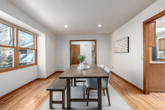 dining room featuring visible vents, light wood-style flooring, and baseboards