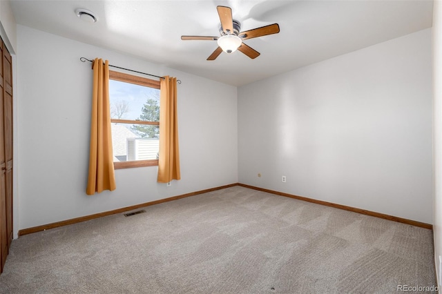 empty room with a ceiling fan, baseboards, visible vents, and light carpet