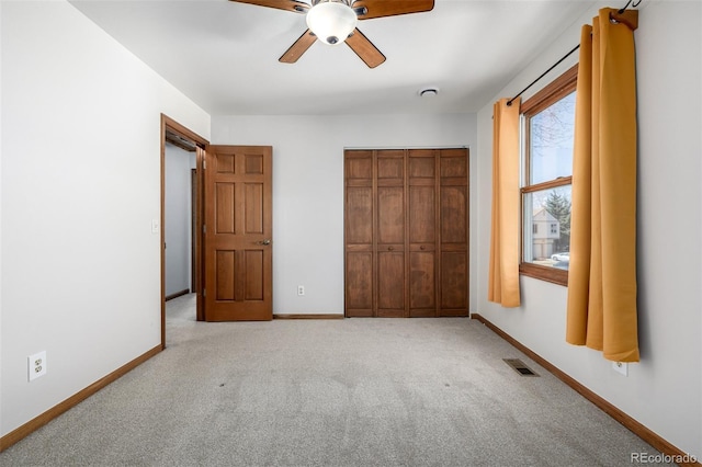 unfurnished bedroom featuring carpet flooring, baseboards, visible vents, and a closet