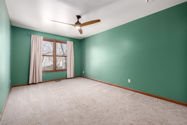 carpeted empty room featuring visible vents, ceiling fan, and baseboards