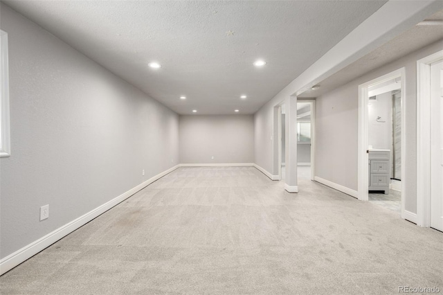 below grade area with recessed lighting, a textured ceiling, baseboards, and carpet floors