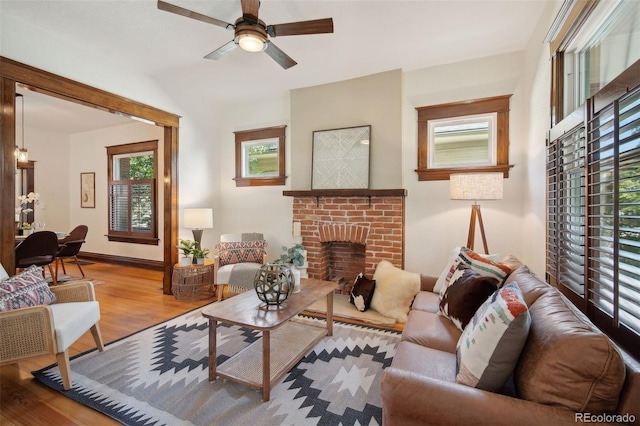 living room featuring a fireplace, light hardwood / wood-style flooring, and ceiling fan