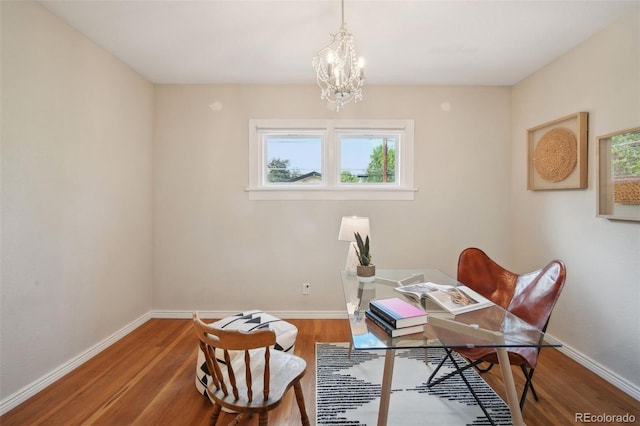 home office with hardwood / wood-style floors and a chandelier