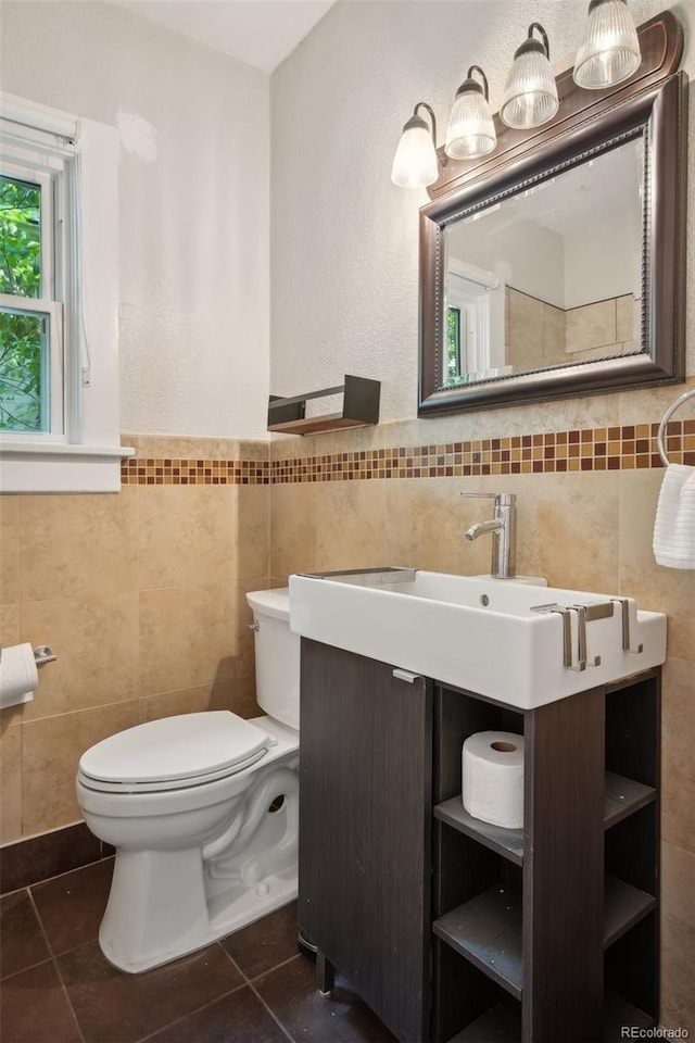 bathroom featuring tile patterned floors, vanity, tile walls, and toilet