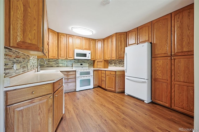 740 S Alton Way Unit 2A, Denver, CO 80247 - kitchen with white appliances, light countertops, decorative backsplash, light wood-type flooring, and brown cabinetry