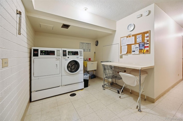 740 S Alton Way Unit 2A, Denver, CO 80247 - shared laundry featuring washing machine and dryer and a textured ceiling