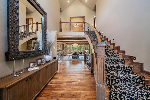 8090 S Homesteader Dr, Morrison, CO 80465 - foyer entrance featuring high vaulted ceiling, stairway, and light wood finished floors